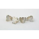 A set of four Edwardian silver triangular napkin rings by Wakely & Wheeler