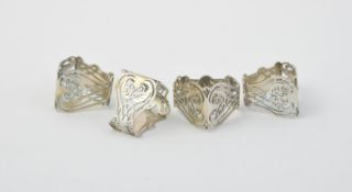 A set of four Edwardian silver triangular napkin rings by Wakely & Wheeler