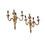 A pair of French gilt metal three light wall appliques in Louis XVI style