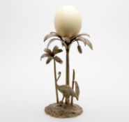 A plated table centrepiece in the form of two entwined palm trees with ostrich below