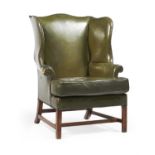 A green leather upholstered wing armchair