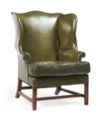 A green leather upholstered wing armchair