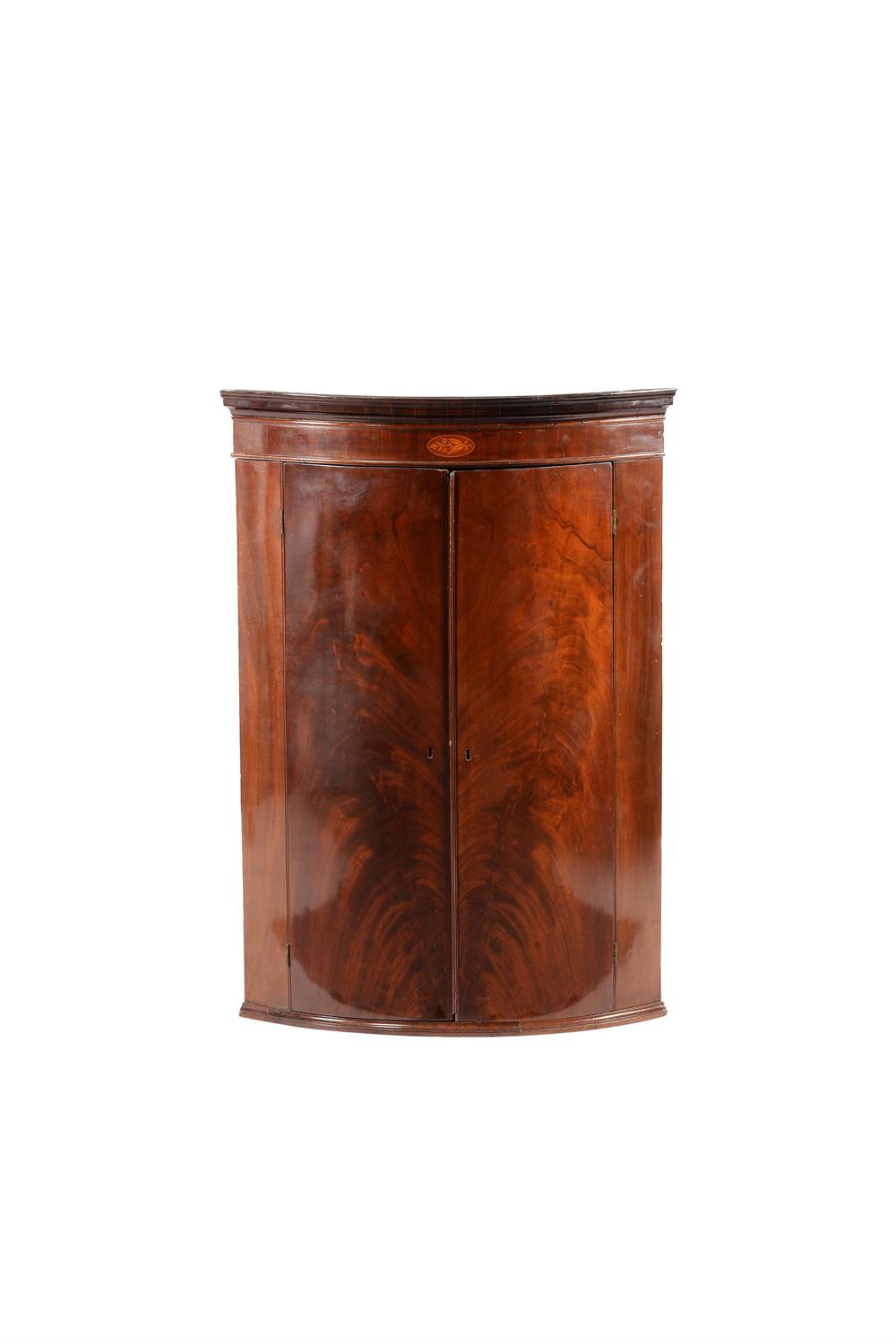 A George III flame mahogany corner cupboard