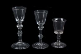 A group of three various light baluster wine glasses