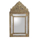 A repousse brass framed marginal wall mirror