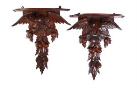 A pair of Continental carved walnut wall brackets