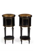 A pair of ebonised and gilt metal mounted cylindrical bedside cabinets