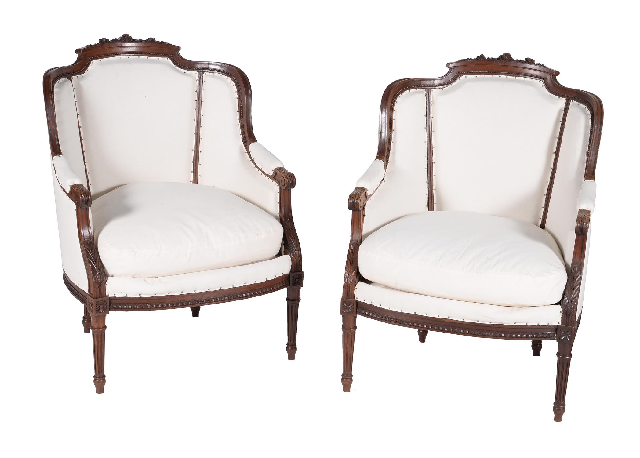 A pair of French carved mahogany armchairs in Louis XVI style