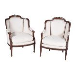 A pair of French carved mahogany armchairs in Louis XVI style