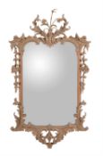 A carved and stripped limewood wall mirror in 18th century style