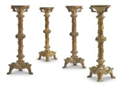 A SET OF FOUR GOTHIC REVIVAL GILT BRASS CANDLESTICKS