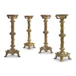 A SET OF FOUR GOTHIC REVIVAL GILT BRASS CANDLESTICKS