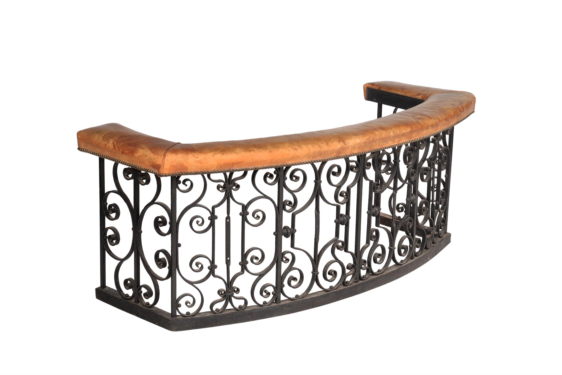 A wrought iron and leather upholstered club fender