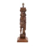 A carved oak figural table lamp