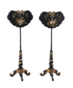 Y A near pair of early Victorian black lacquered and parcel gilt papier Mâché pole screens