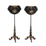 Y A near pair of early Victorian black lacquered and parcel gilt papier Mâché pole screens