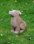 A sculpted red limestone model of a seated dog