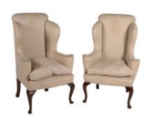 A pair of stained hardwood and upholstered wingback armchairs