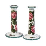 Two similar Wemyss style Abbotsford Ware tapered cylindrical candlesticks painted with cabbage roses