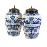 A pair of Dutch Delft blue and white tobacco jars and brass covers