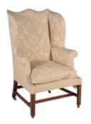 A George III mahogany and upholstered wing armchair