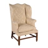 A George III mahogany and upholstered wing armchair