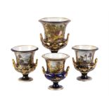 A garniture of three Derby blue-ground and gilt campana urns painted with titled landscape views in
