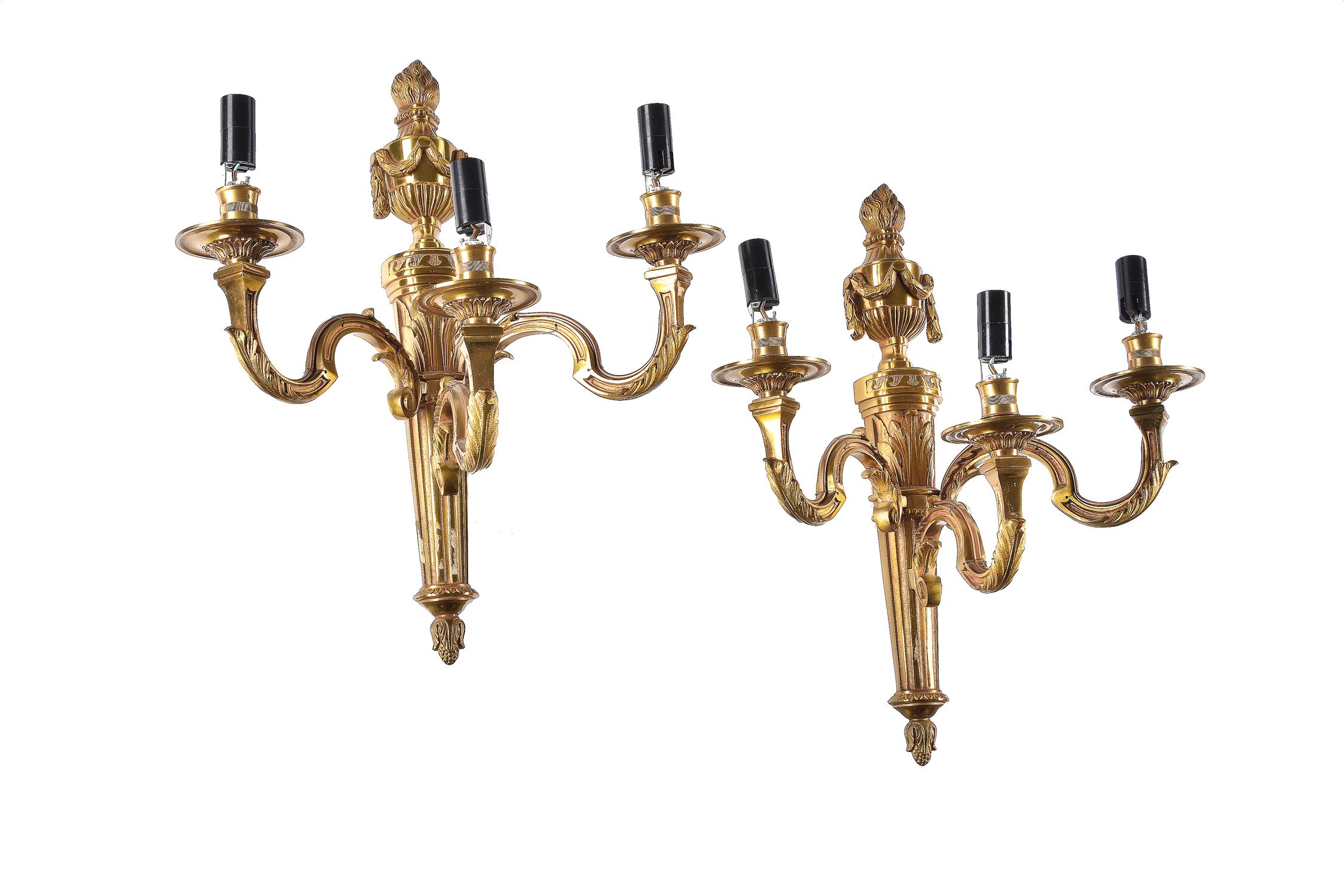 A pair of French gilt metal three light wall appliques in Louis XVI style