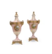 A pair of French porcelain Serves-style pink-ground and gilt two-handled vases and covers