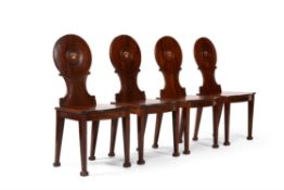 A set of four George III mahogany hall chairs