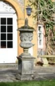 A large stone composition urn on plinth