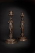 A pair of Neoclassical patinated bronze figural candlesticks