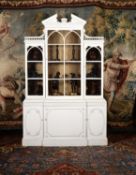 A cream painted carved wood bookcase, in George III style