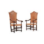 A pair of Italian walnut and leather upholstered armchairs