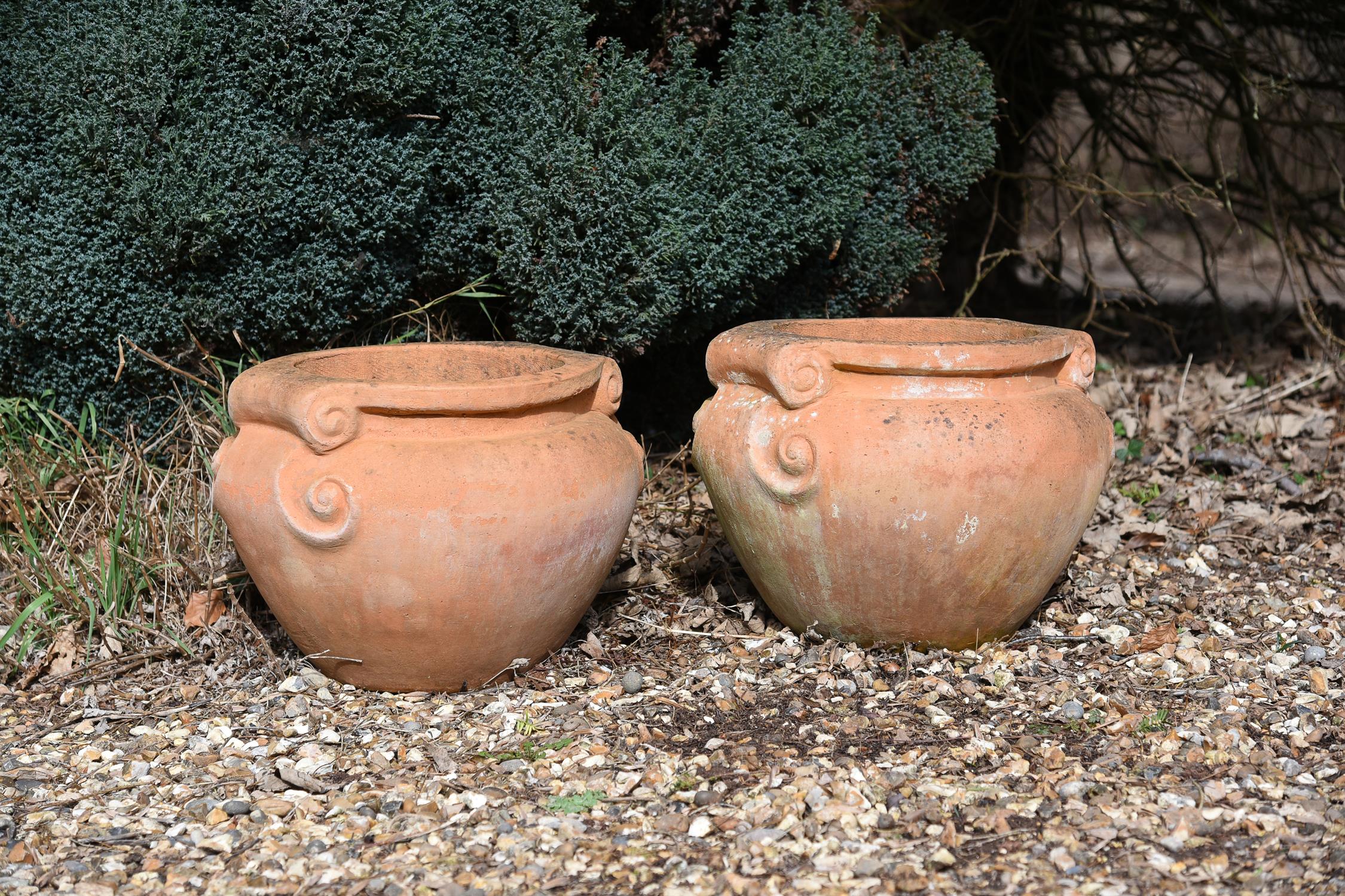 A pair of terracotta jardinieres in the style of examples by the Compton Pottery