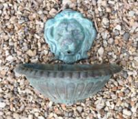 A verdigris bronze lion mask wall fount