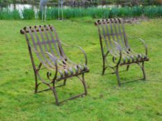 A pair of wrought iron garden armchairs