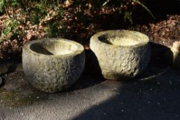 A pair of rough-hewn stone planters