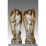 A pair of French sculpted and polychrome decorated terracotta figural torcheres modelled as angels