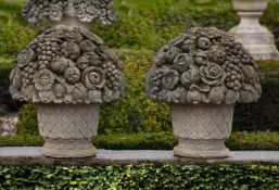A pair of large Continental carved limestone baskets of flowers and fruit in 18th century style