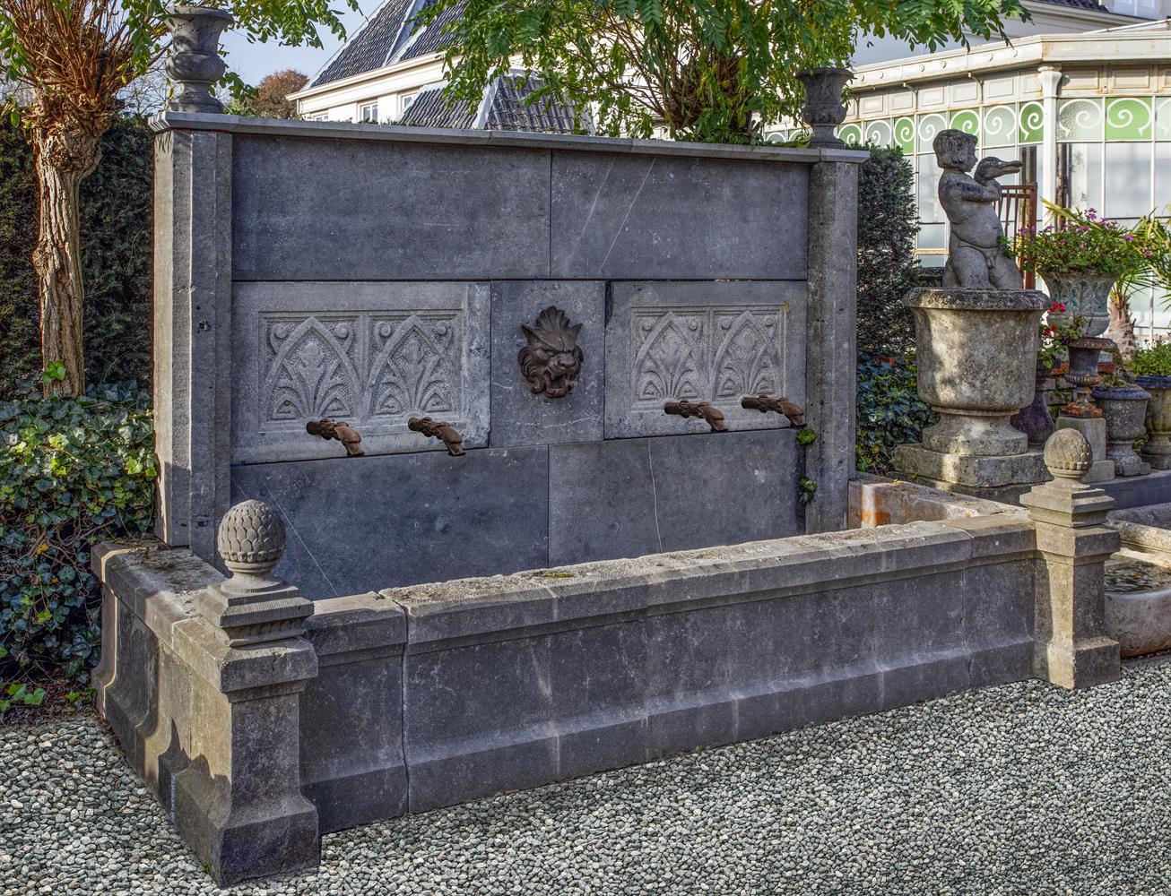 A monumental carved stone wall fountain