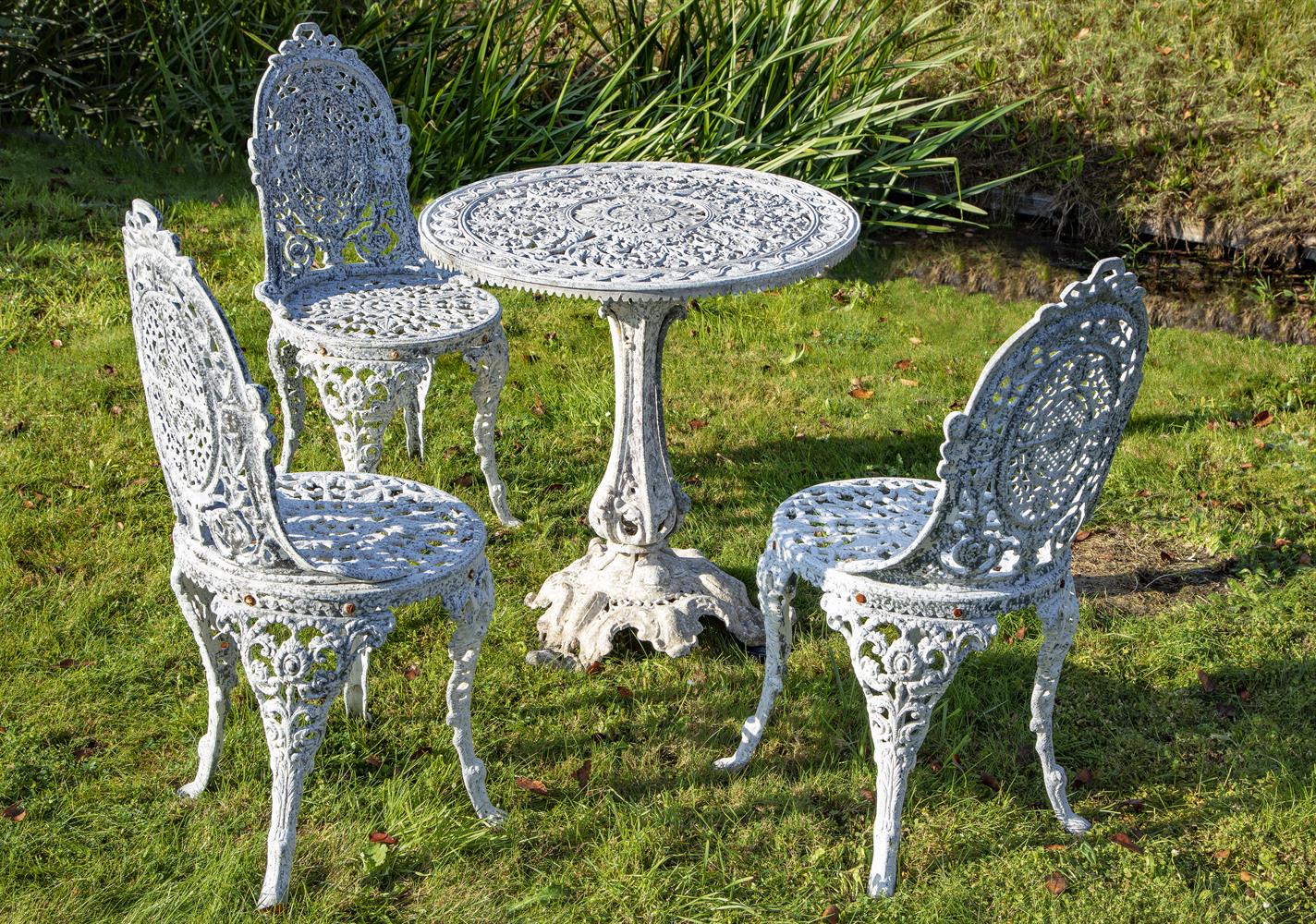 A white painted aluminium suite of garden furniture in Victorian taste