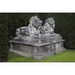 A pair of substantial and impressive stone composition garden models of recumbent lions