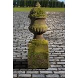 A carved red sandstone urn-on-plinth