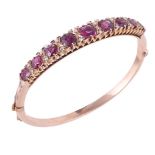 An early 20th century garnet and diamond hinged bangle