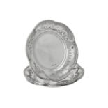 An Edwardian set of four silver shaped circular dishes by Goldsmiths & Silversmiths Co. Ltd.