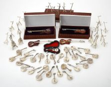 A collection of silver stringed musical instrument pendant boxes and stands