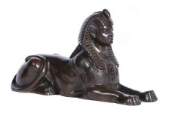 A patinated bronze model of a sphinx