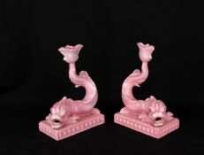 A pair of Wedgwood pink-glazed dolphin candlesticks