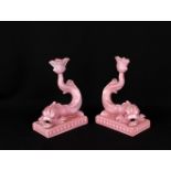 A pair of Wedgwood pink-glazed dolphin candlesticks